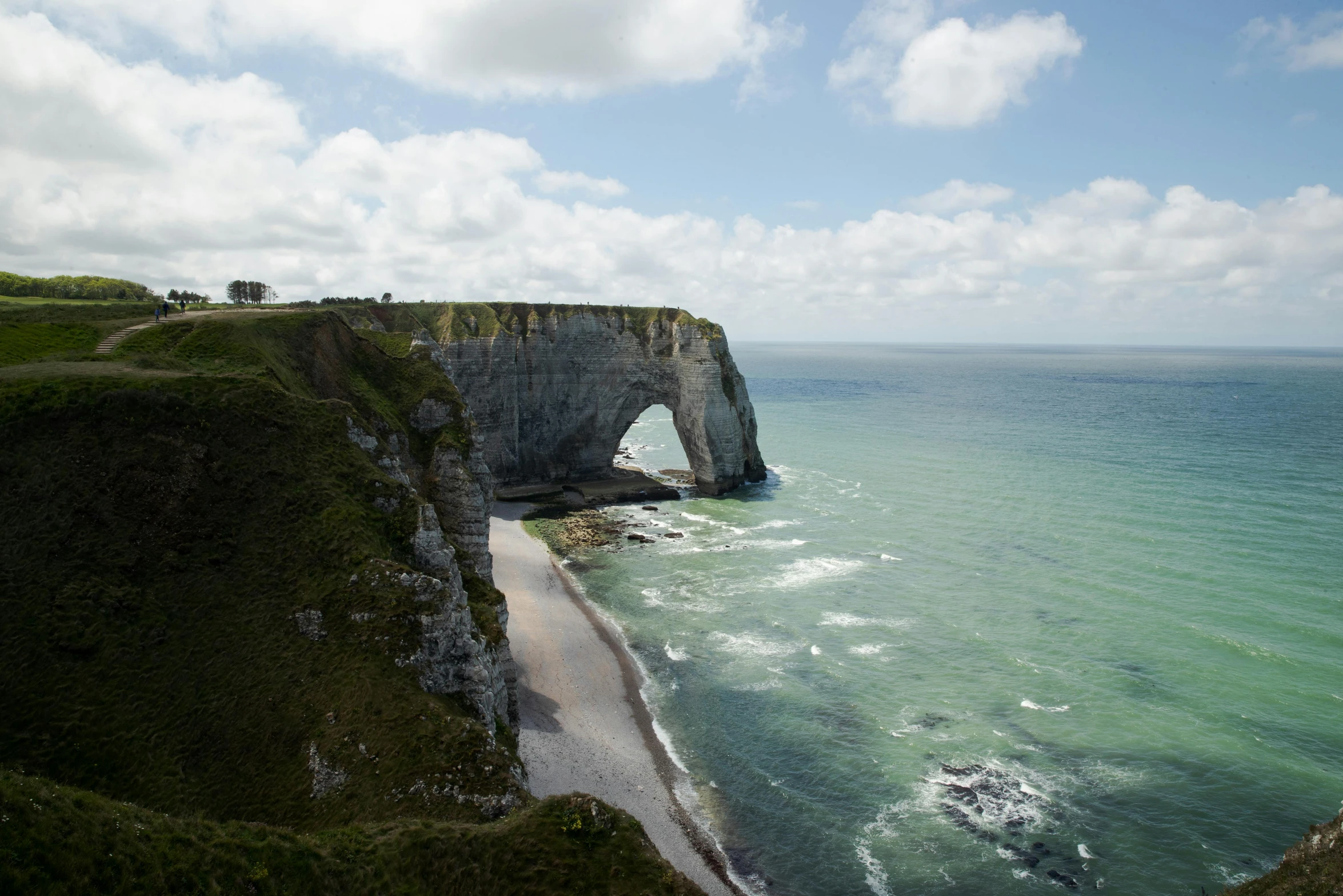 a large body of water next to a cliff, by Raphaël Collin, pexels contest winner, the normandy landings, arch, slide show, a cozy