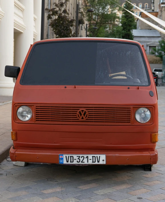 a red van parked on the side of a street, by Attila Meszlenyi, fully frontal view, restoration, 🚿🗝📝