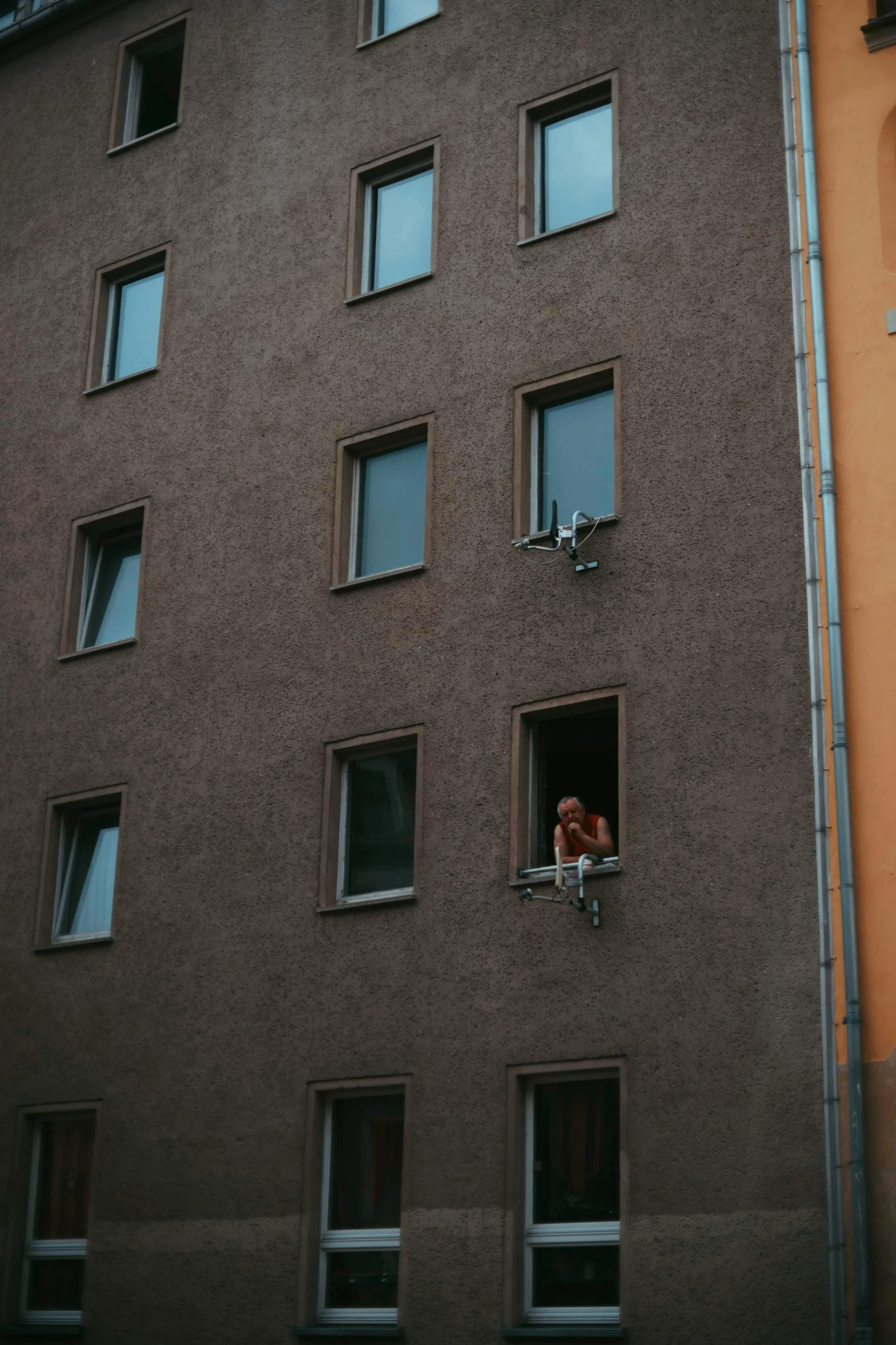 a couple of people that are looking out of a window, munich, cramped, fire from some windows, climber