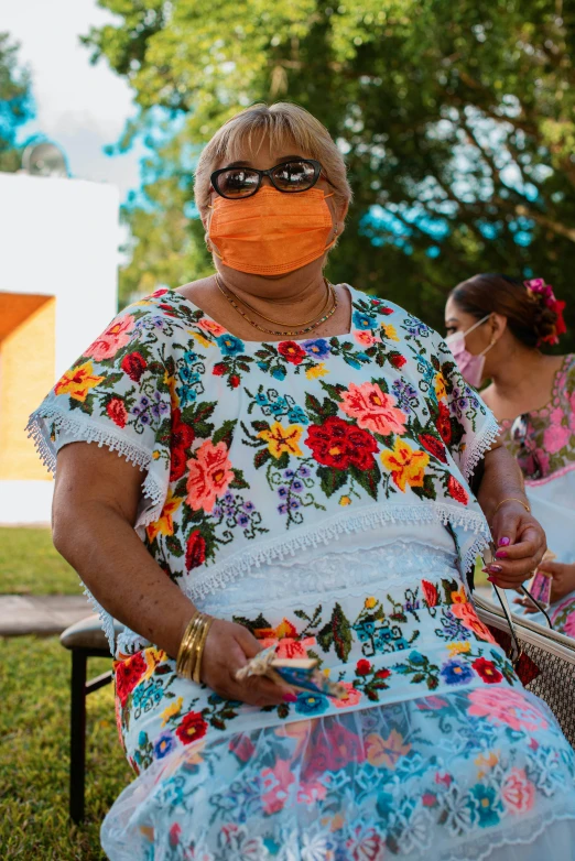 a woman with a face mask sitting on a bench, folklorico, wearing orange sunglasses, nursing home, profile image