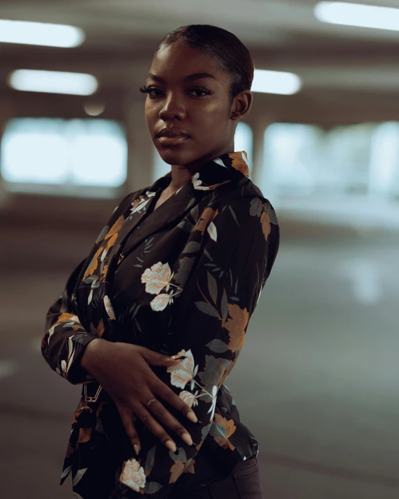 a woman standing in an empty parking garage, by Cosmo Alexander, dark skinned, floral clothes, promo image, portrait featured on unsplash