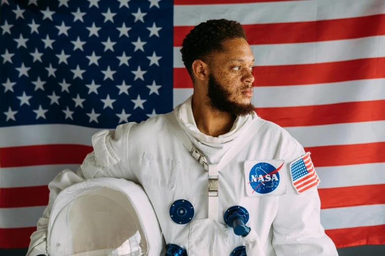 a man standing in front of an american flag, pexels contest winner, renaissance, wearing astronaut outfit, afroamerican, photo from a promo shoot, chemistry