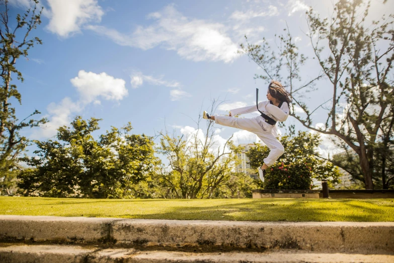 a man flying through the air while riding a skateboard, inspired by Baiōken Eishun, unsplash, happening, in marijuanas gardens, karate outfit, girl dancing on cliff, capoeira