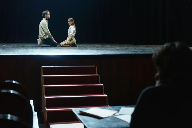 a man and a woman sitting on a stage, unsplash, figuration libre, scene from live action movie, school class, ap art, 15081959 21121991 01012000 4k