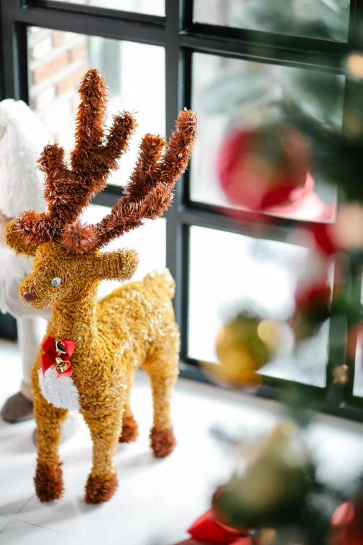 a stuffed reindeer standing in front of a window, zoomed out shot, ornaments, with soft bushes, sparkling