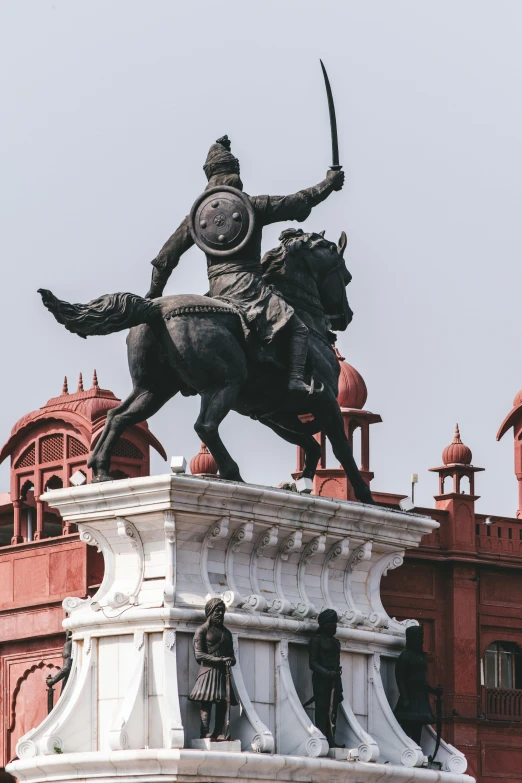 a statue of a man on a horse in front of a building, inspired by Sardar Sobha Singh, pexels contest winner, black and reddish color armor, dome, malayalis attacking, square