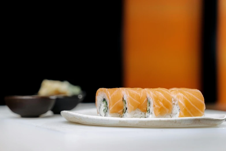 a white plate topped with sushi on top of a table, a picture, during the day