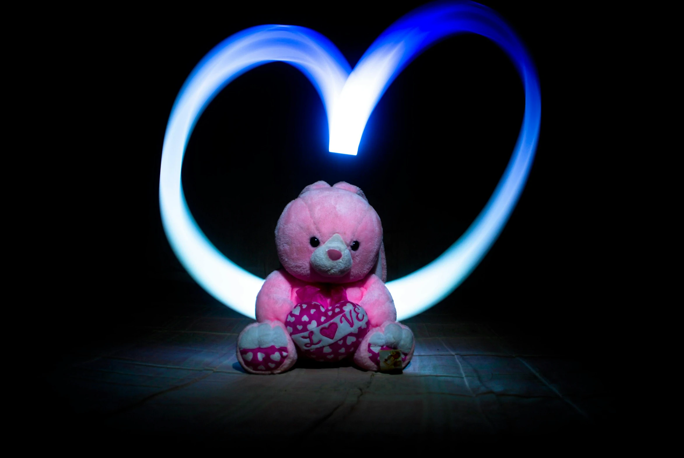 a teddy bear sitting in front of a heart shaped light, a picture, by Toyen, pink and blue colour, bunny, lightpainting, islamic