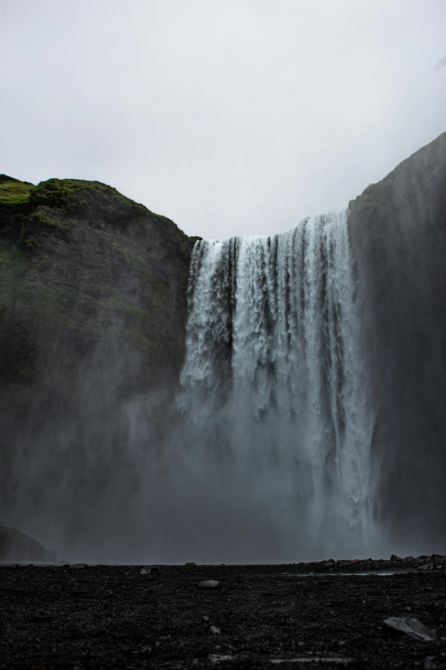 a person standing in front of a waterfall, by Terese Nielsen, pexels contest winner, hurufiyya, looking threatening, a gigantic wall, viewed from a distance, photo taken in 2018