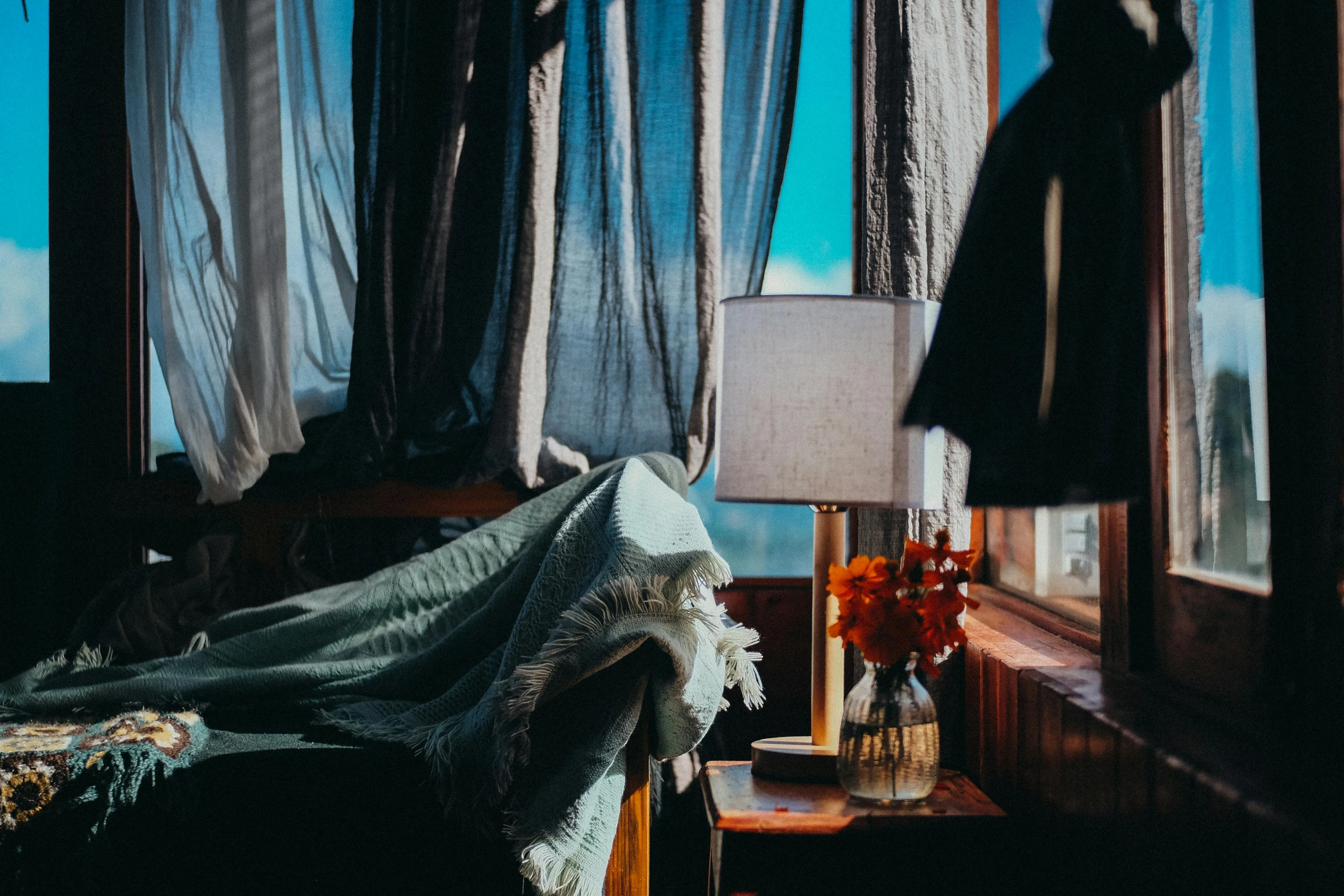 a bed sitting in a bedroom next to a window, a still life, trending on unsplash, magical realism, fully covered in drapes, lantern light besides, morning light showing injuries, light inside the hut