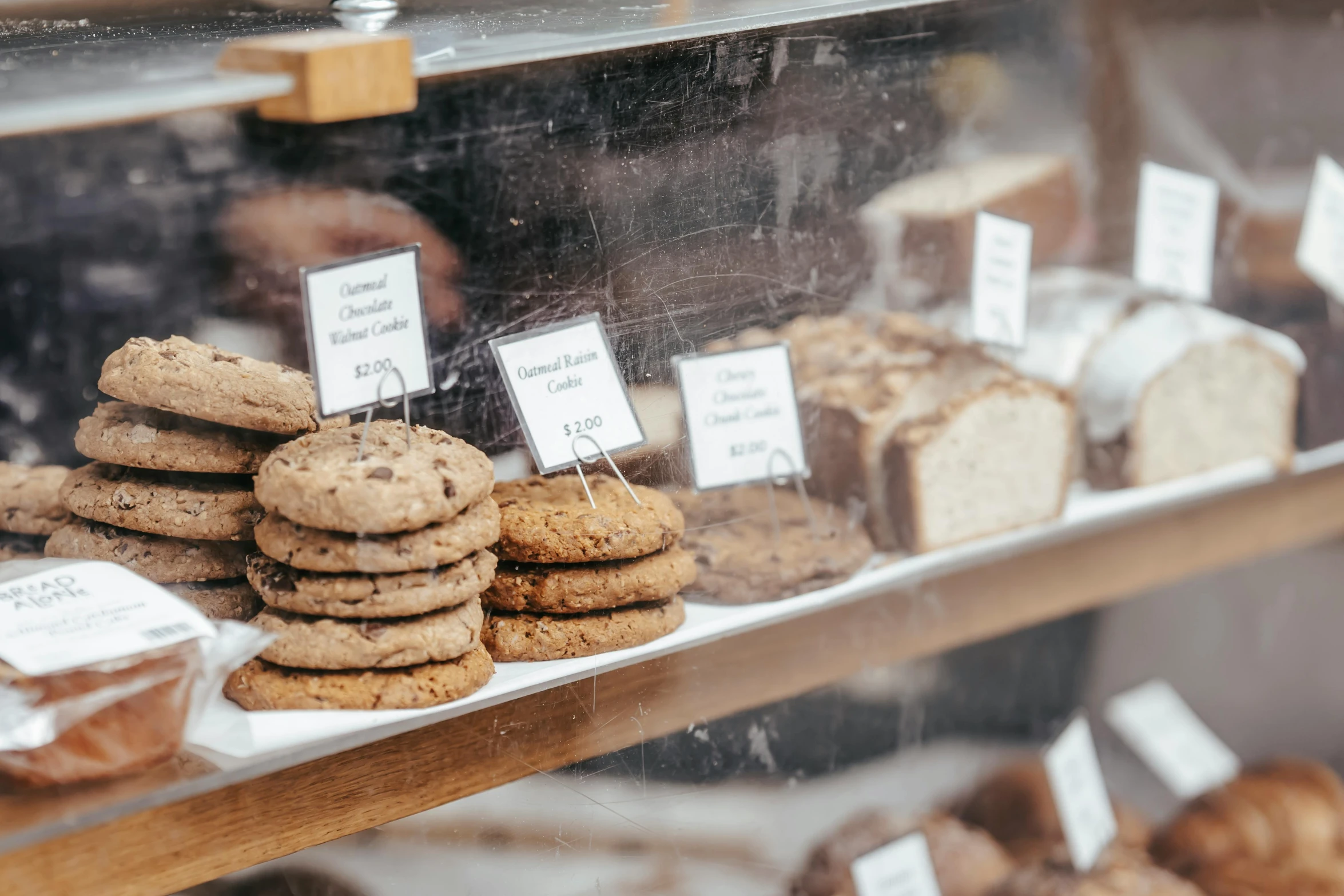 a display case filled with lots of cookies and pastries, by Emma Andijewska, trending on pexels, sustainable materials, rain lit, thumbnail, 1 2 9 7