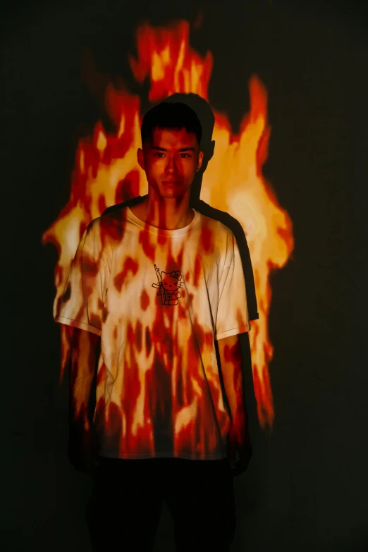 a man that is standing in front of a fire, an album cover, inspired by Wang Zhenpeng, trending on pexels, wearing a t-shirt, headshot, speculative fashion, studio lit