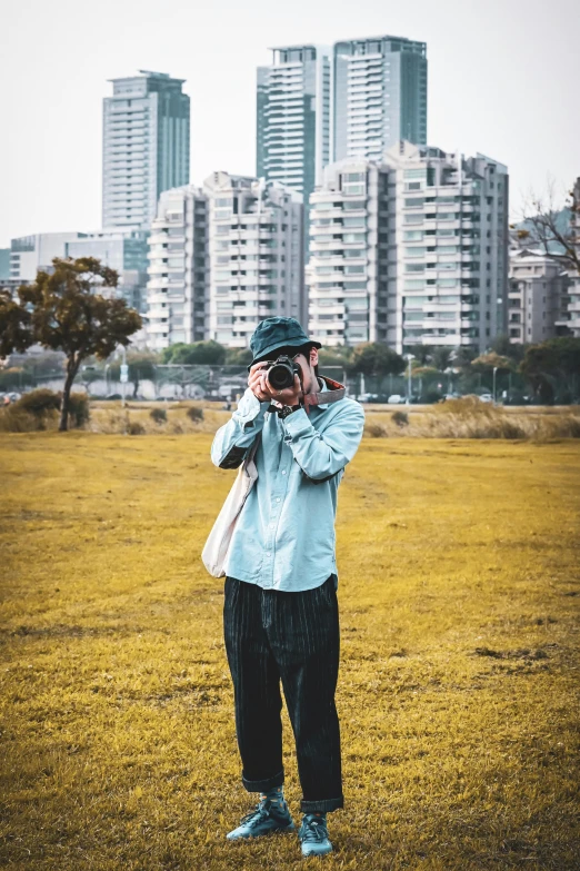 a man standing in a field taking a picture with a camera, in tokio, color photography, 2022 photograph, portrait mode photo