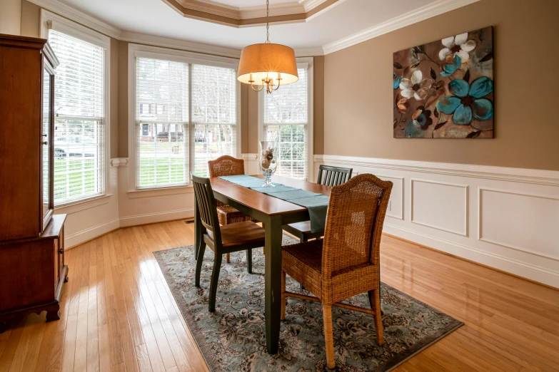 a dining room with a table and chairs, by Carey Morris, pexels contest winner, bay window, areas rugs, hardwood floor, professionally post - processed