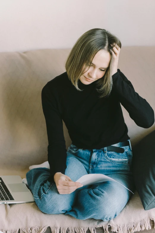 a woman sitting on a couch with a laptop, pexels contest winner, realism, black turtle neck shirt, stressing out, with notes, wearing a dark shirt and jeans