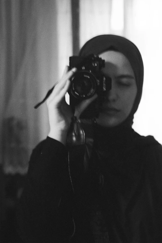 a woman taking a picture with a camera, inspired by irakli nadar, hijab, monochrome:-2, lofi, demna gvasalia