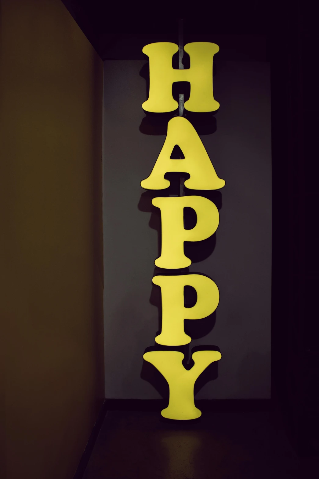 a yellow happy sign hanging from the side of a wall, a picture, by Chippy, unsplash, display”, medium closeup, c 4 d ”, colorful”
