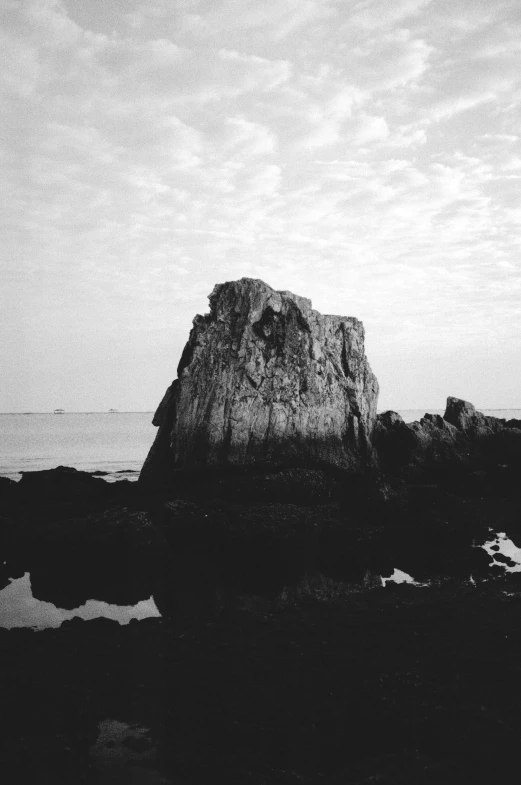 a black and white photo of a rock in the ocean, by Bascove, medium format, jiyun chae, :: morning, ((monolith))