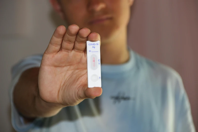 a man holding a wii remote in his hand, a picture, unsplash, renaissance, pathology sample test tubes, male teenager, nasal strip, 33mm photo