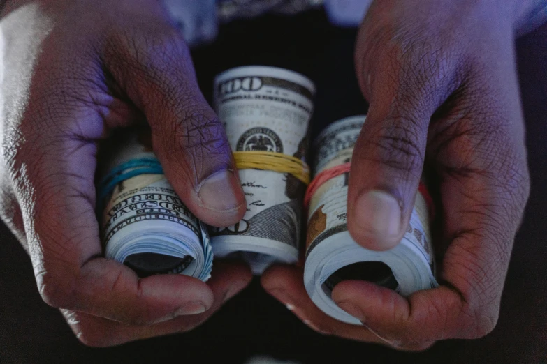 a person holding a bunch of money in their hands, a portrait, pexels contest winner, black main color, intro to uncut gems, multi colored, stacks