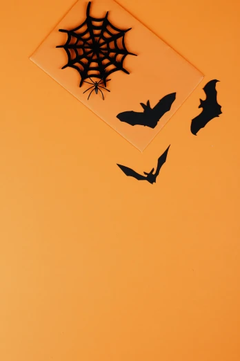 a couple of bats that are flying in the air, a cartoon, trending on pexels, negative space, resin, halloween theme, cardstock