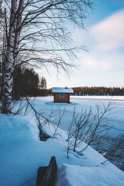 a small cabin sitting on top of a snow covered field, inspired by Einar Hakonarson, pexels contest winner, winter lake setting, today\'s featured photograph 4k, build in a forest near of a lake, low detailed