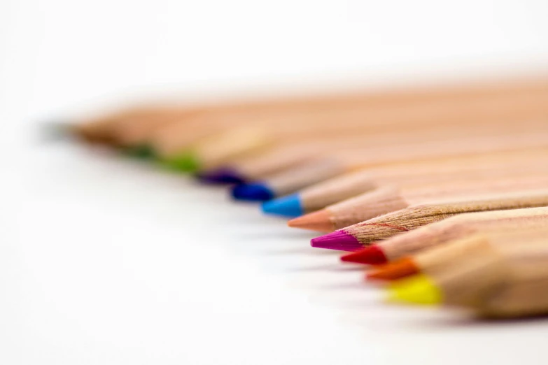 a row of colored pencils on a white surface, by Carey Morris, pexels, very shallow depth of field, colourised, ilustration, fine line detail