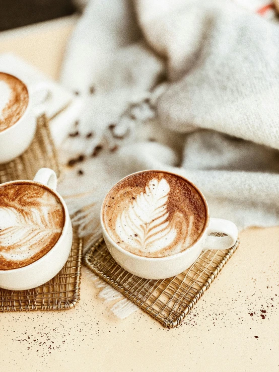 a couple of cups of coffee sitting on top of a table, profile image, thumbnail, creamy skin, product shot