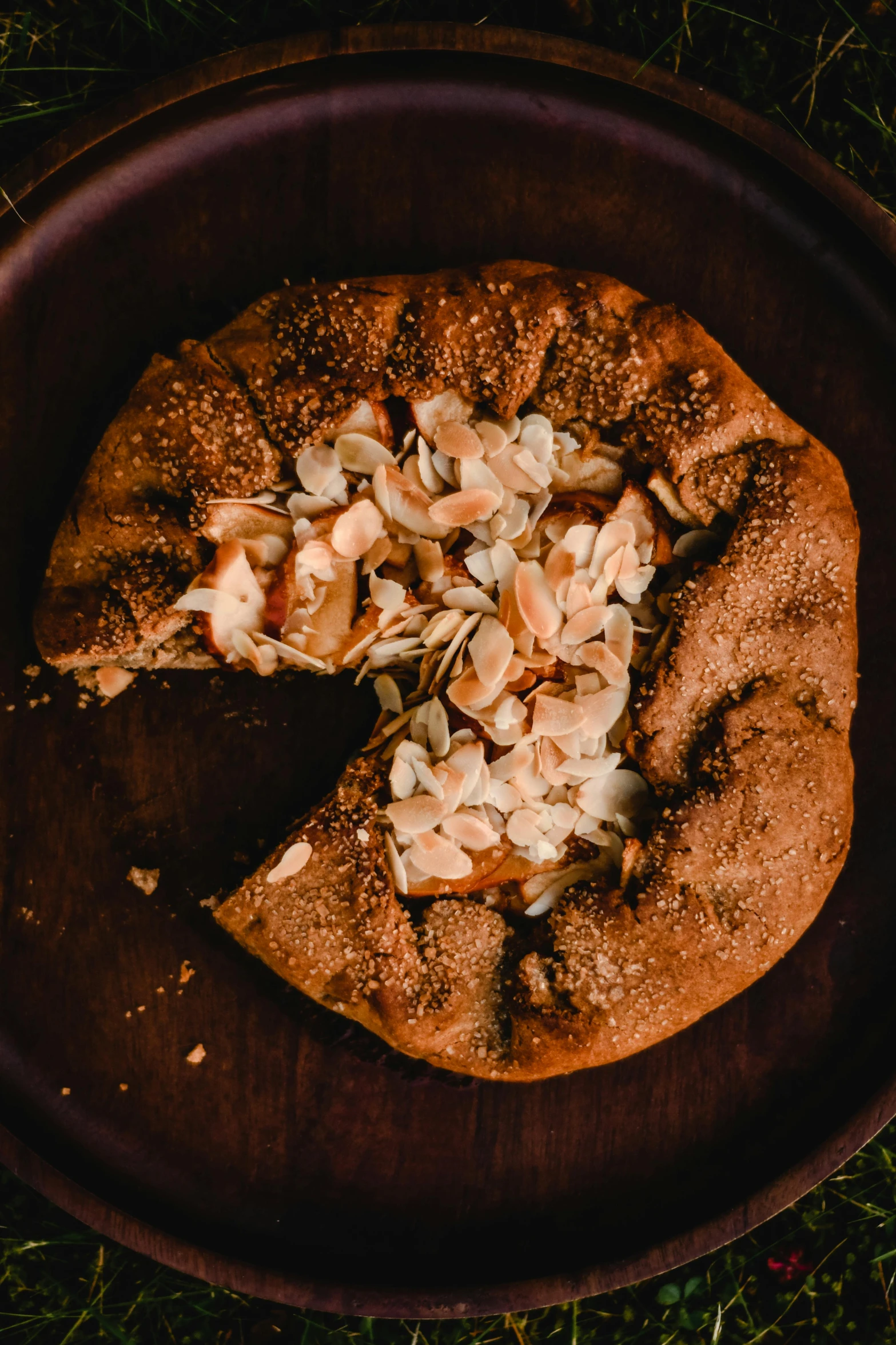 a pizza sitting on top of a wooden plate, cinnamon, ouroboros, fully covered, alphonse muca