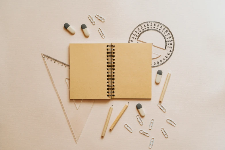 an open notebook sitting on top of a table, beige color scheme, educational supplies, 9 9 designs, flatlay