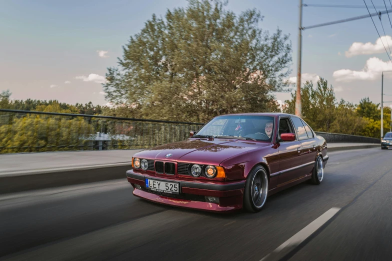 a red car driving down a road next to a forest, a portrait, unsplash contest winner, renaissance, bmw e 3 0, filtered evening light, elaborate polished, 🚿🗝📝