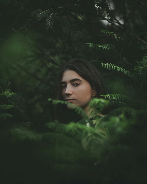 a woman standing in the middle of a forest, a polaroid photo, inspired by Elsa Bleda, unsplash contest winner, with green eyes, with soft bushes, portrait of florence pugh, in a garden full of ferns