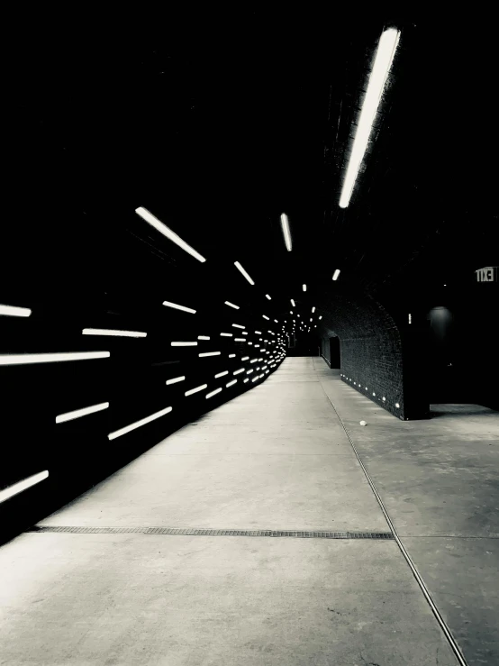 a black and white photo of a subway station, light and space, on a black wall, instagram picture, pathway, emissive lights