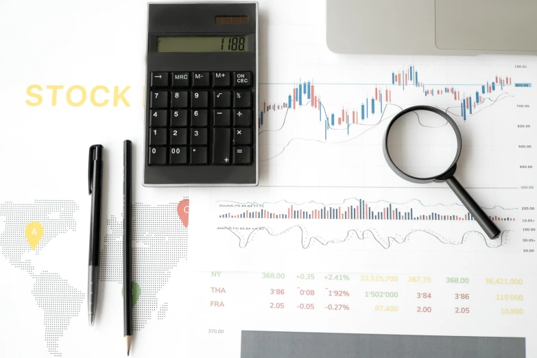 a calculator sitting on top of a desk next to a laptop, a picture, pexels, analytical art, trading stocks, black and yellow and red scheme, creek, black on white background