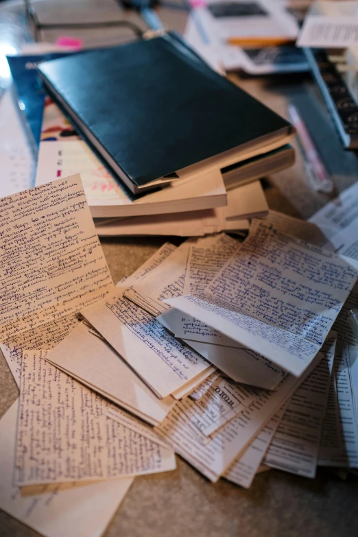 a pile of books sitting on top of a table, found scribbled in a notebook, 2019 trending photo, two stories, found papers