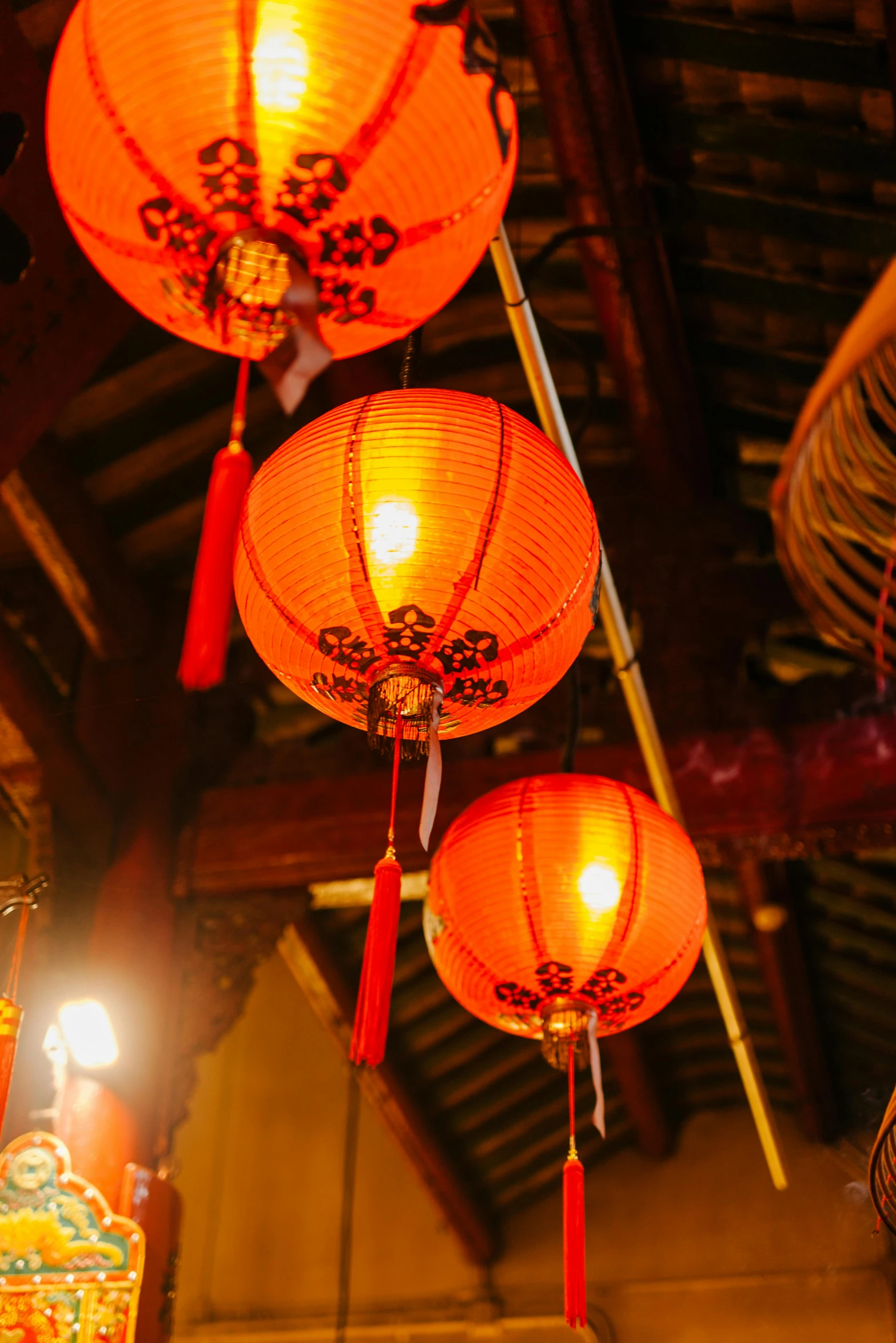 a bunch of red lanterns hanging from the ceiling, warm orange lighting, vietnamese temple scene, square, medium - shot