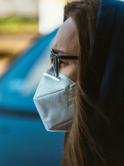 a woman wearing a face mask in front of a car, by Adam Marczyński, pexels contest winner, happening, close up shot from the side, profile image, cardboard, avatar image