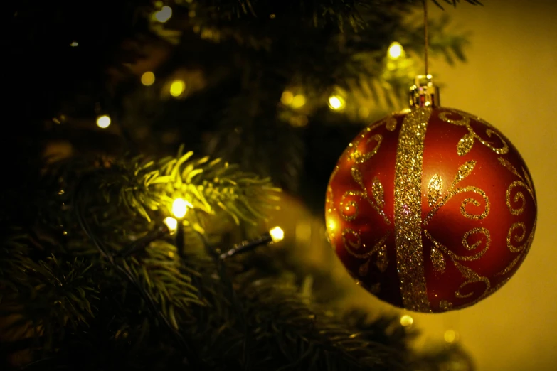 a red ornament hanging from a christmas tree, by Alice Mason, pexels, baroque, golden orbs and fireflies, brown, led, profile image