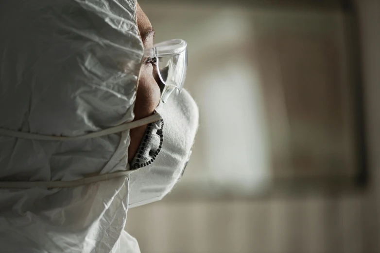 a close up of a person wearing a protective suit, by Patrick Pietropoli, unsplash, hyperrealism, wearing lab coat and glasses, tense atmosphere, fan favorite, cardboard