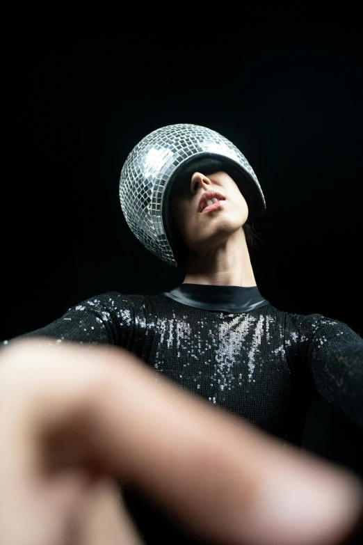 a man with a disco ball on his head, an album cover, inspired by Hedi Xandt, unsplash, zentai suit, high hat, non binary model, photographed for reuters