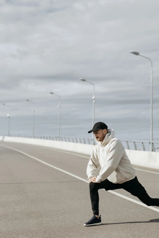 a man riding a skateboard across a bridge, by Christen Dalsgaard, unsplash, man in adidas tracksuit, smoking with squat down pose, on a road, white