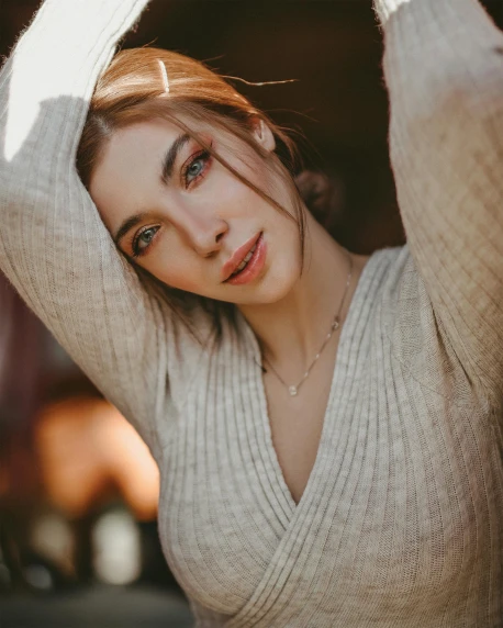 a beautiful young woman posing for a picture, inspired by Elsa Bleda, trending on pexels, renaissance, grey sweater, decolletage, her skin is light brown, young beautiful amouranth