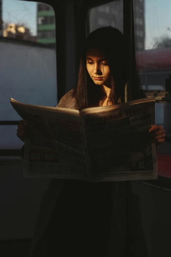 a woman reading a newspaper on a bus, by Adam Marczyński, pexels contest winner, hyperrealism, sun down, woman with black hair, gif, reading in library