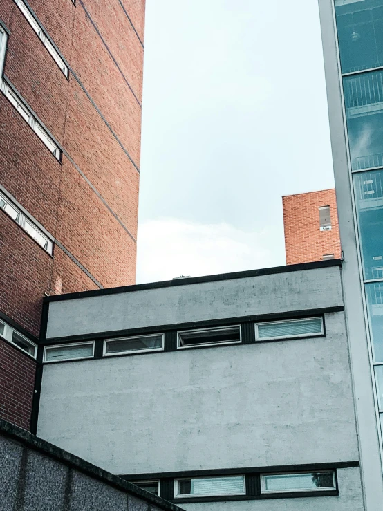 a couple of tall buildings next to each other, a photo, inspired by Bauhaus, unsplash, brutalism, brick building, college, background image, taken in the 2000s