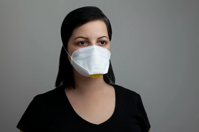 a woman in a black shirt is wearing a white mask, worksafe.2000s, square, on grey background, yellow