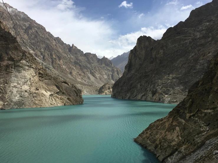 a large body of water surrounded by mountains, by Muggur, pexels contest winner, hurufiyya, ash thorp khyzyl saleem, blue and green water, porcelain skin ”, coloured photo