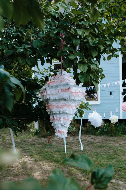 a couple of pinatas hanging from a tree, by Rachel Reckitt, rococo, soft outdoor light, white and pink, cottage close up, award winning