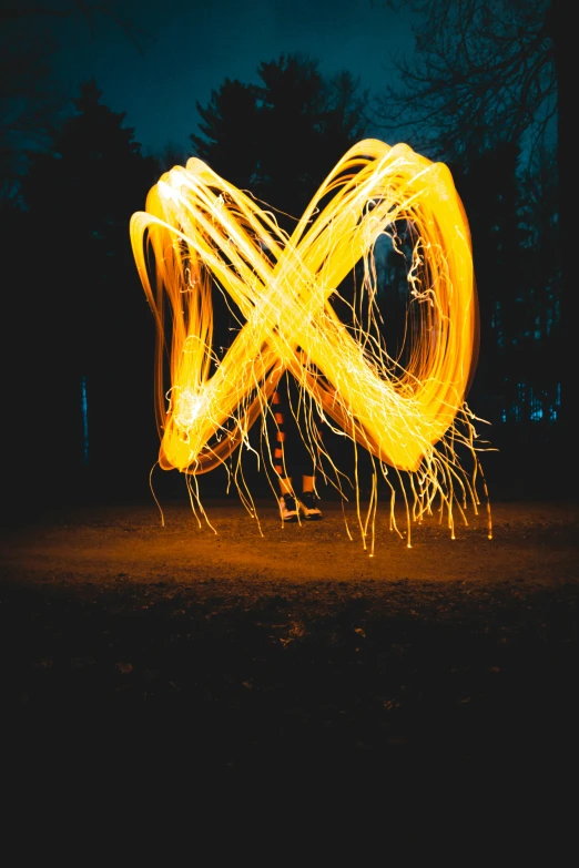 a person standing in the dark with a light painting, pexels contest winner, kinetic art, yellow charcoal, (fire), sparkly, whirly