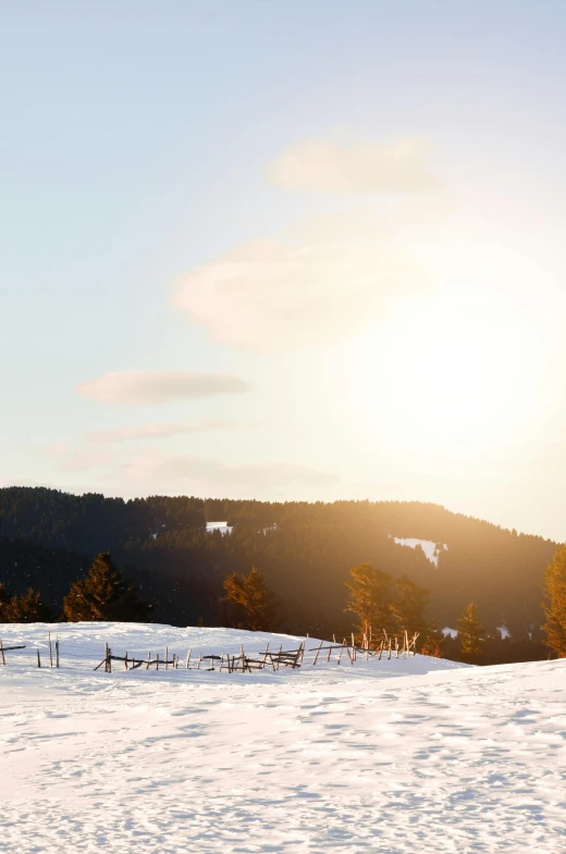 a man riding a snowboard down a snow covered slope, by Franz Hegi, pexels contest winner, sunset panorama, benches, swedish countryside, sparse winter landscape