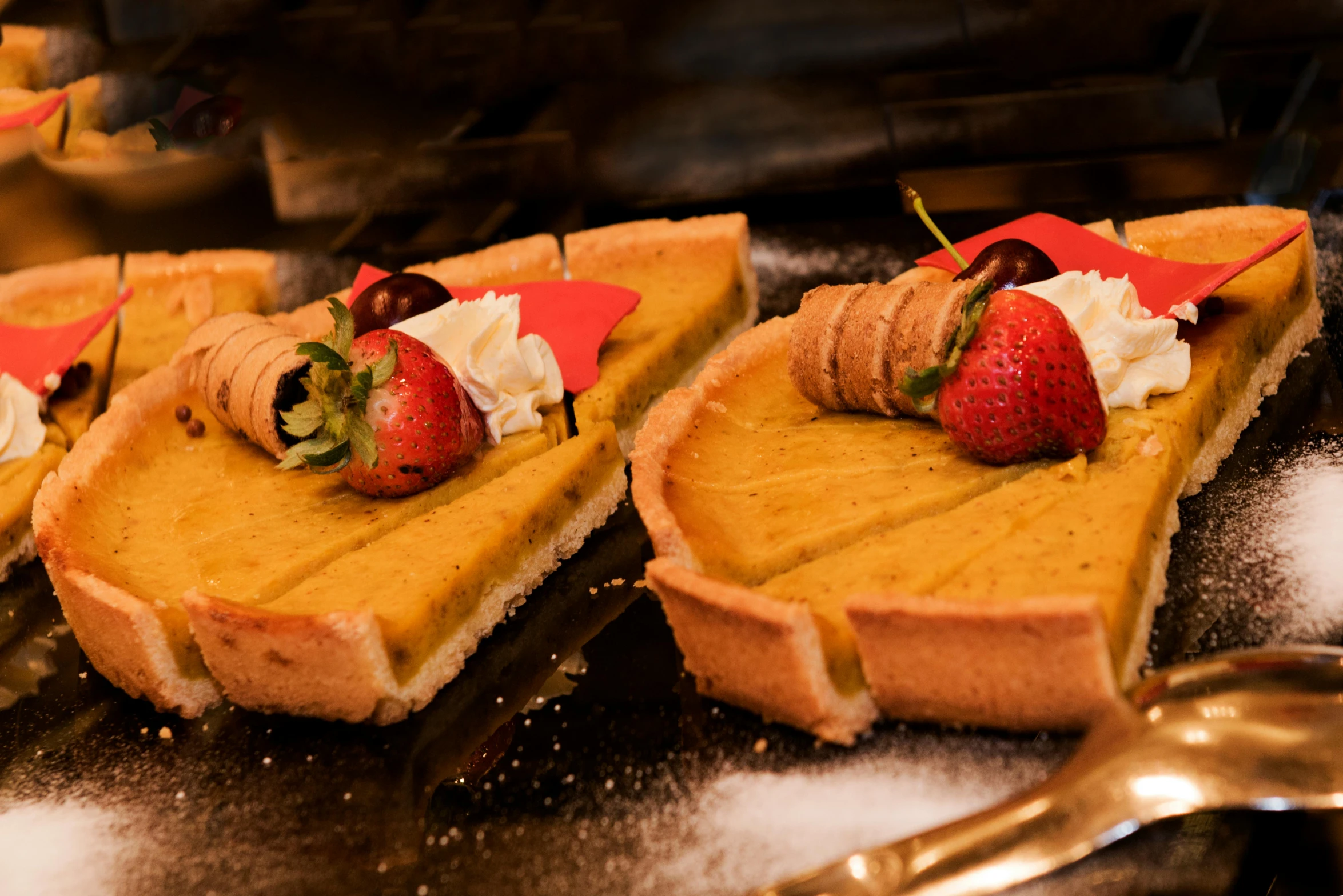 a group of desserts sitting on top of a table, yellow aureole, next to sliced strawberries, medieval feast, woodfired